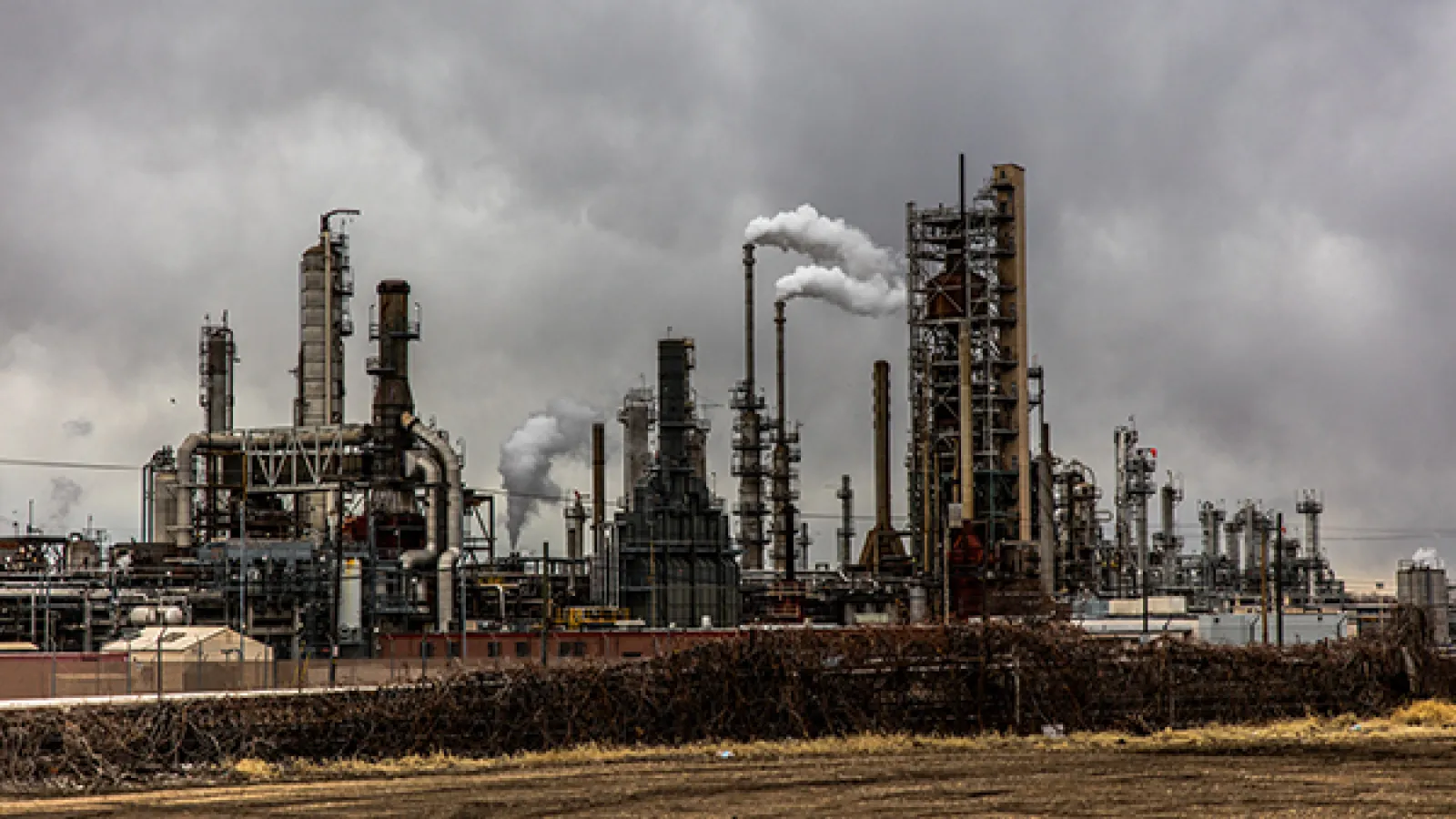 An industrial factory with smoke coming out of smokestacks