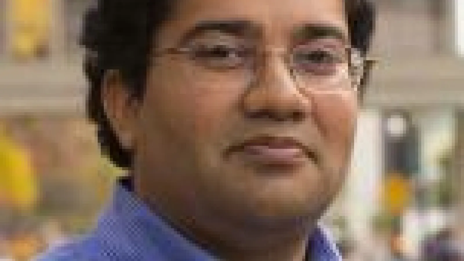 A photo of Srini Parthasarathy outdoors, smiling at the camera