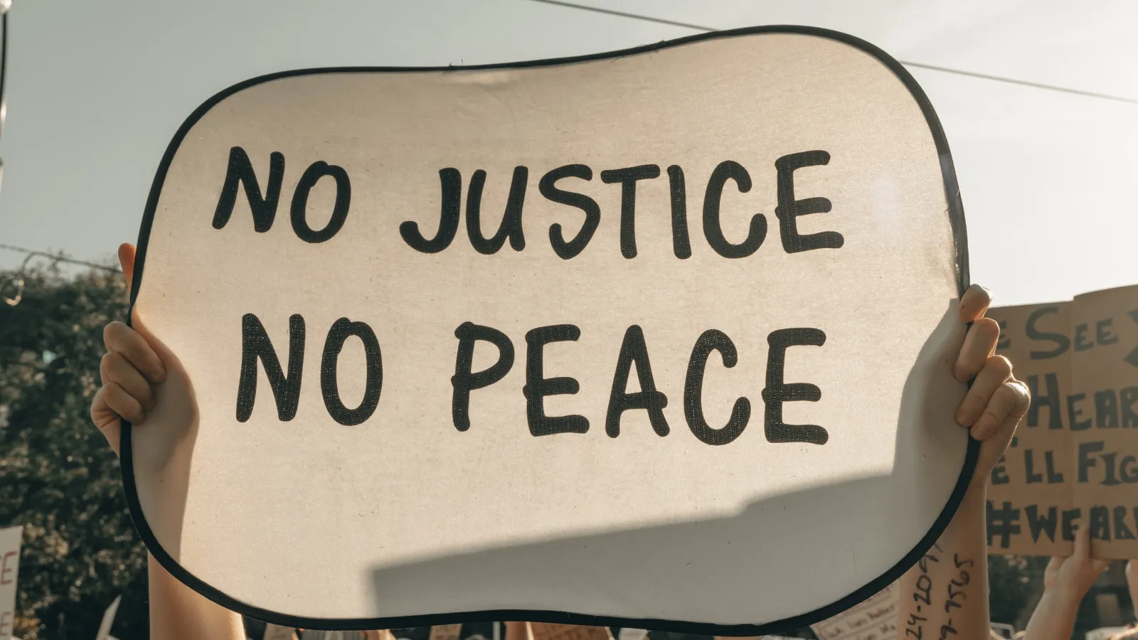 sign at a protest that reads "no justice, no peace"