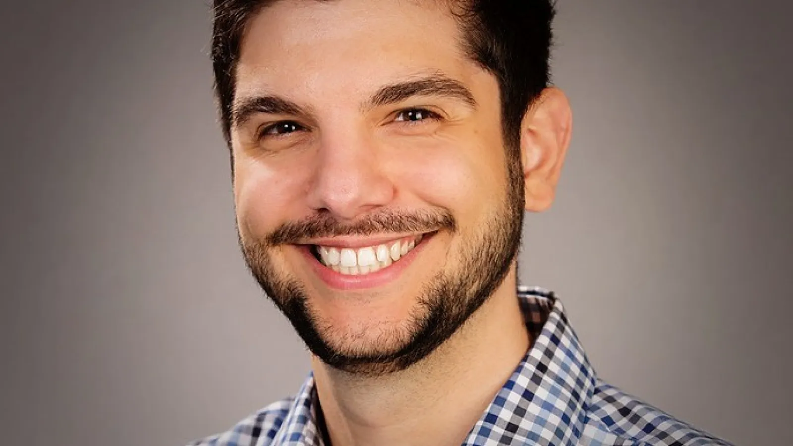 Luka Brkljacic, a white man with neatly trimmed facial hair and short dark hair smiles