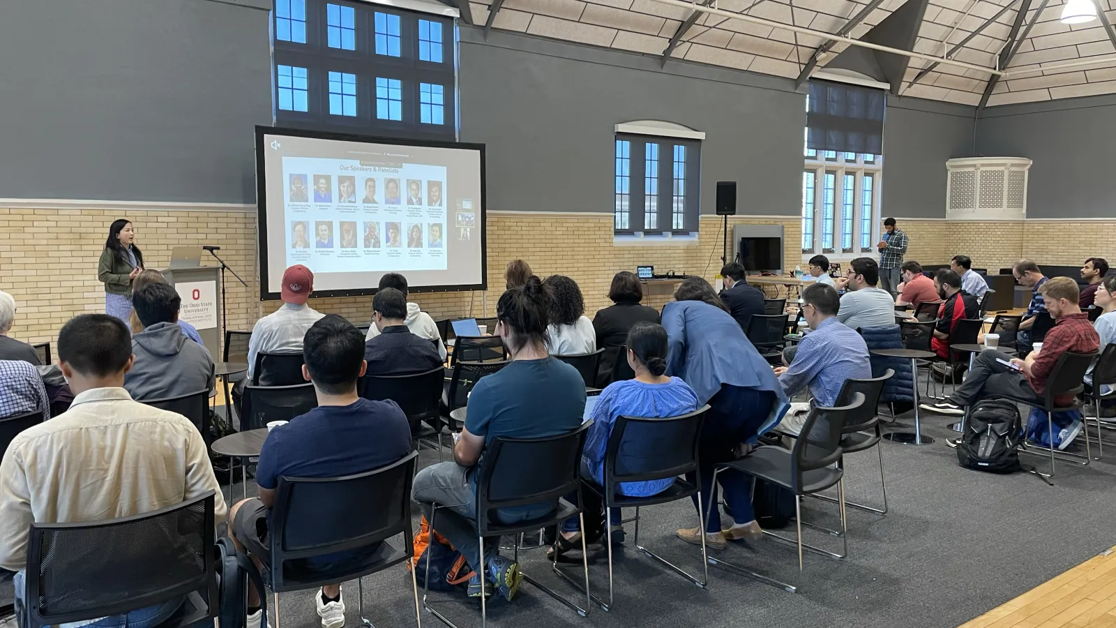 Assoc. Professor Huan Sun speaks to an audience in a bright room with high ceilings