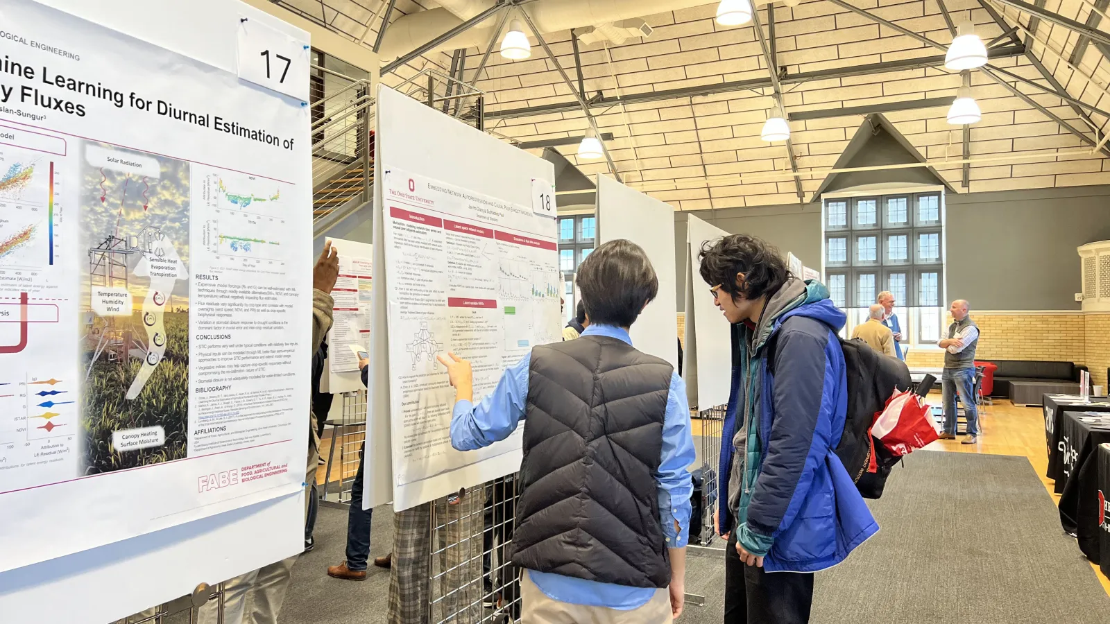 a research student describing his poster to an interested party