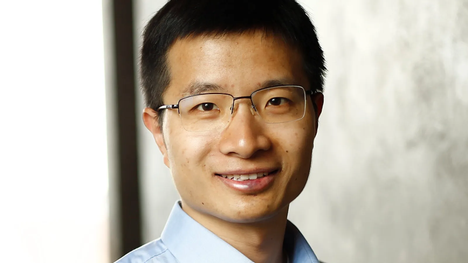 Professor Weijie Su on a gray wall background