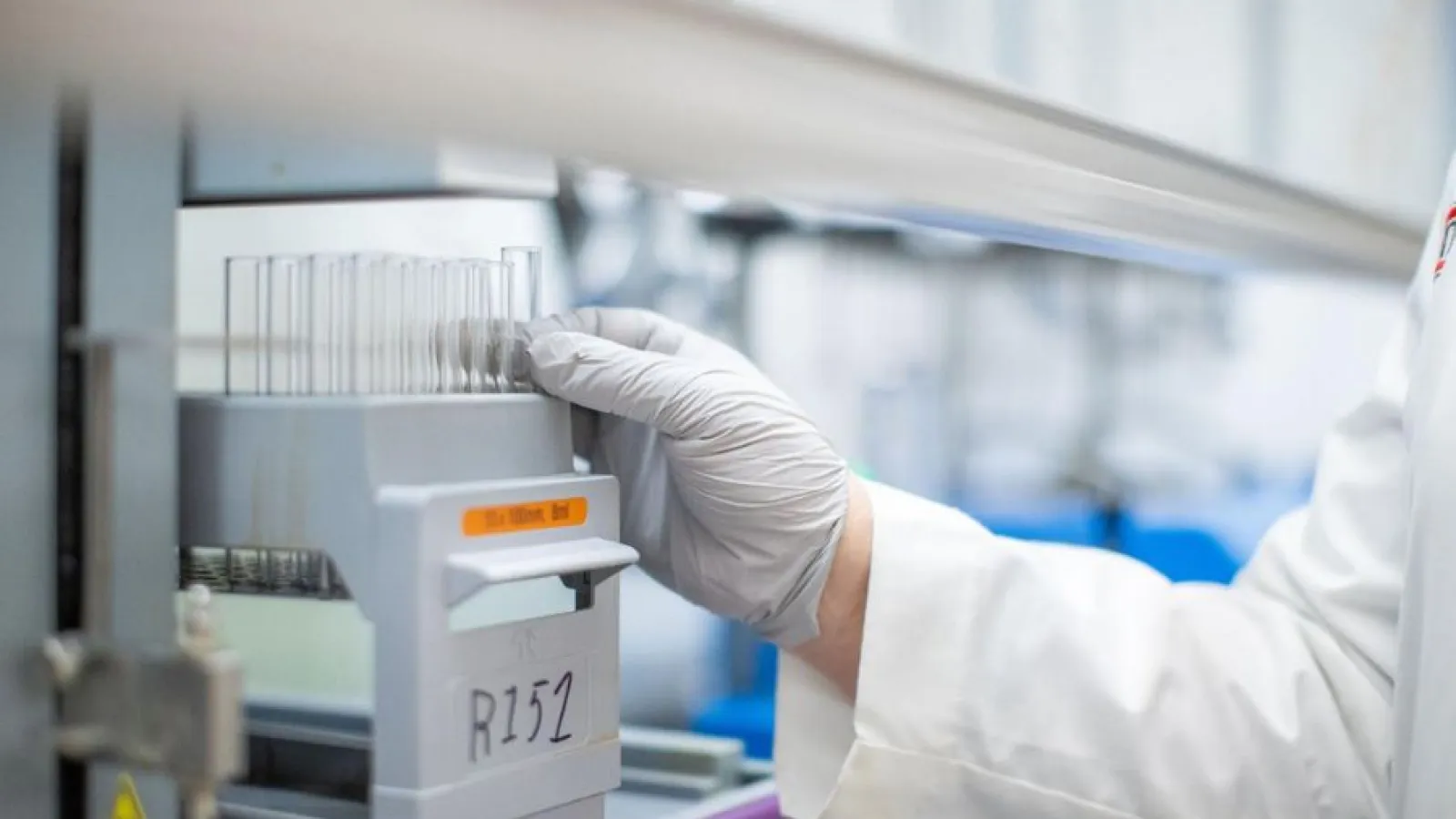Hand reaching for flask in a lab setting
