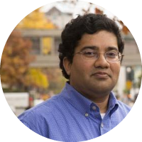 Headshot of Srinivasan Parthasarathy wearing glasses and a blue shirt, photographed outdoors.