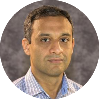 Headshot of Rizwan Ahmad wearing a collared shirt, smiling slightly against a neutral background.