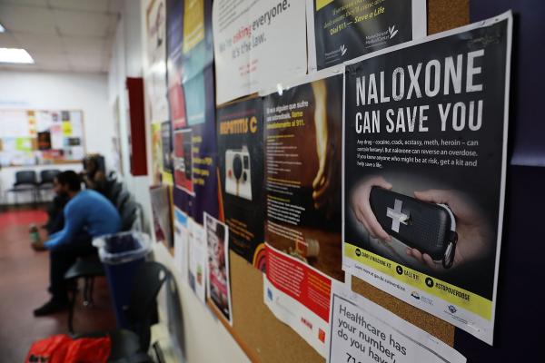 An photo of a bulletin board with a flyer that reads "Naloxone can save you"