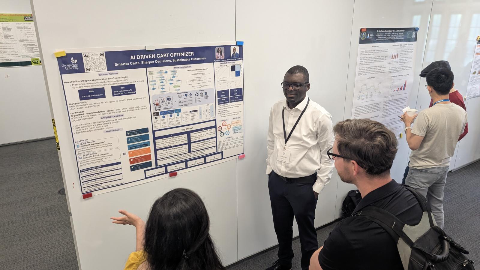 Conference Attendees listening to someone discuss their poster and research