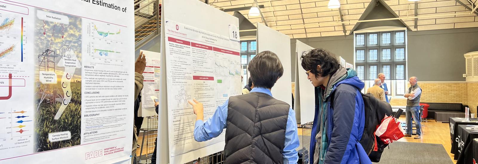 a research student describing his poster to an interested party