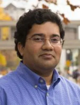 A photo of Srini Parthasarathy outdoors, smiling at the camera