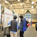 People talking in front educational posters at the event