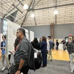 People talking in front educational posters at the event