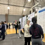 People talking in front educational posters at the event
