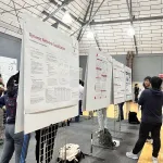 People talking in front educational posters at the event
