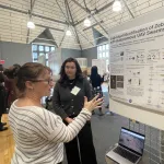 Jenna Kline talking with attendee about Identification of Zebras with Autonomous UAV swarms